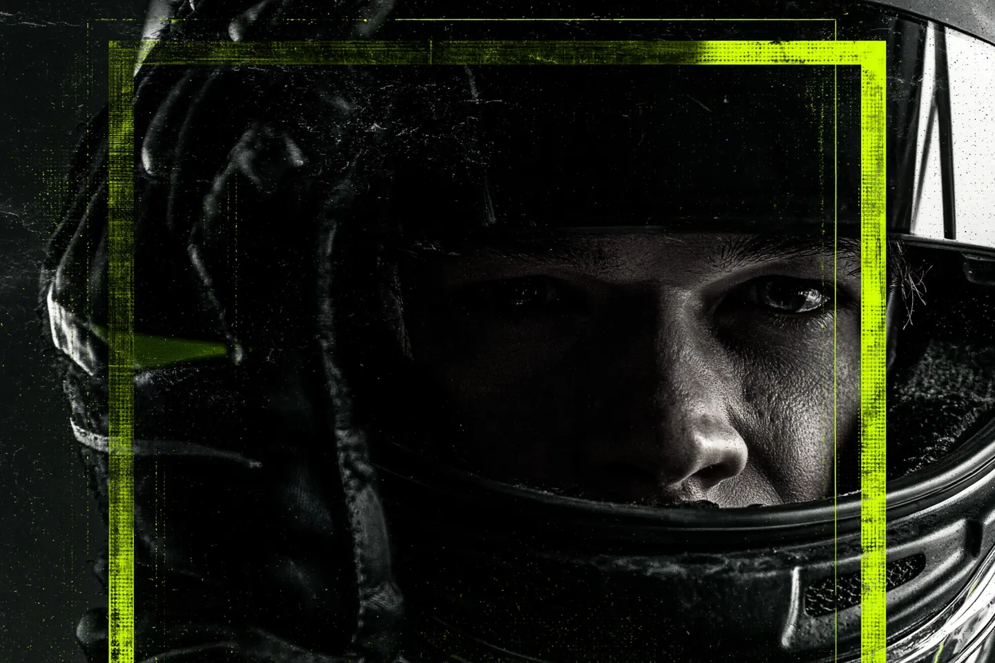 Helmeted racing driver staring ahead through a dark visor with one gloved hand raised beside the helmet